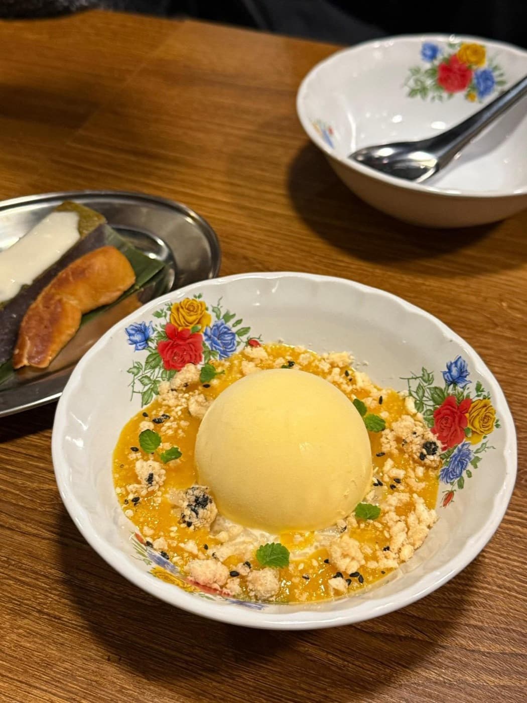 Mango dessert — a scoop of sorbet with passionfruit and crumble in a floral bowl