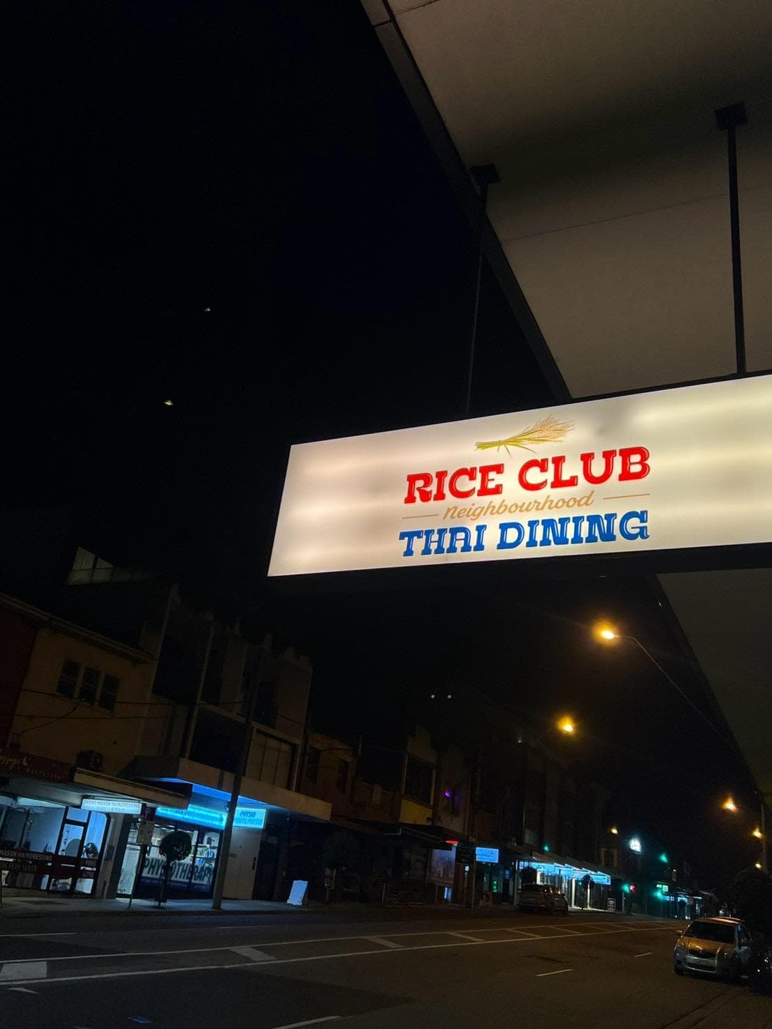 The Rice Club neighbourhood sign lit up on High Street, Glen Iris at night