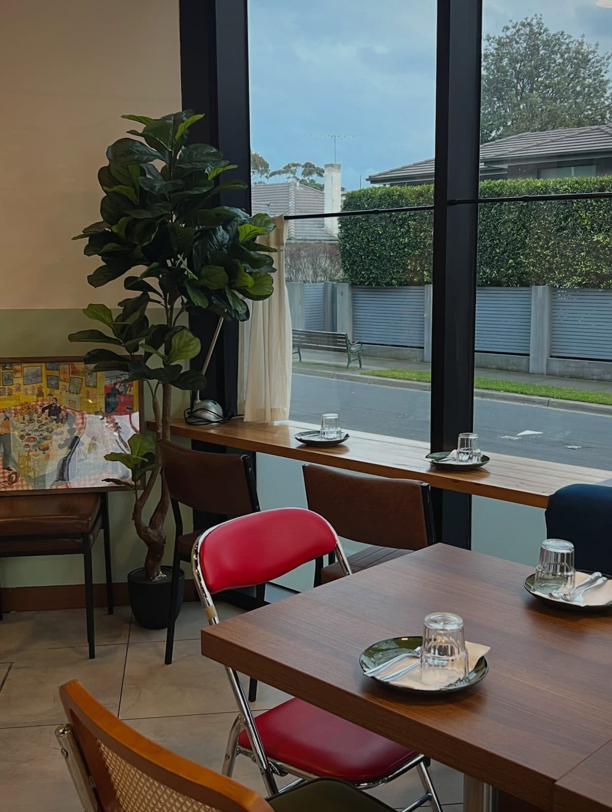 A window banquette with a potted plant and afternoon light inside Rice Club